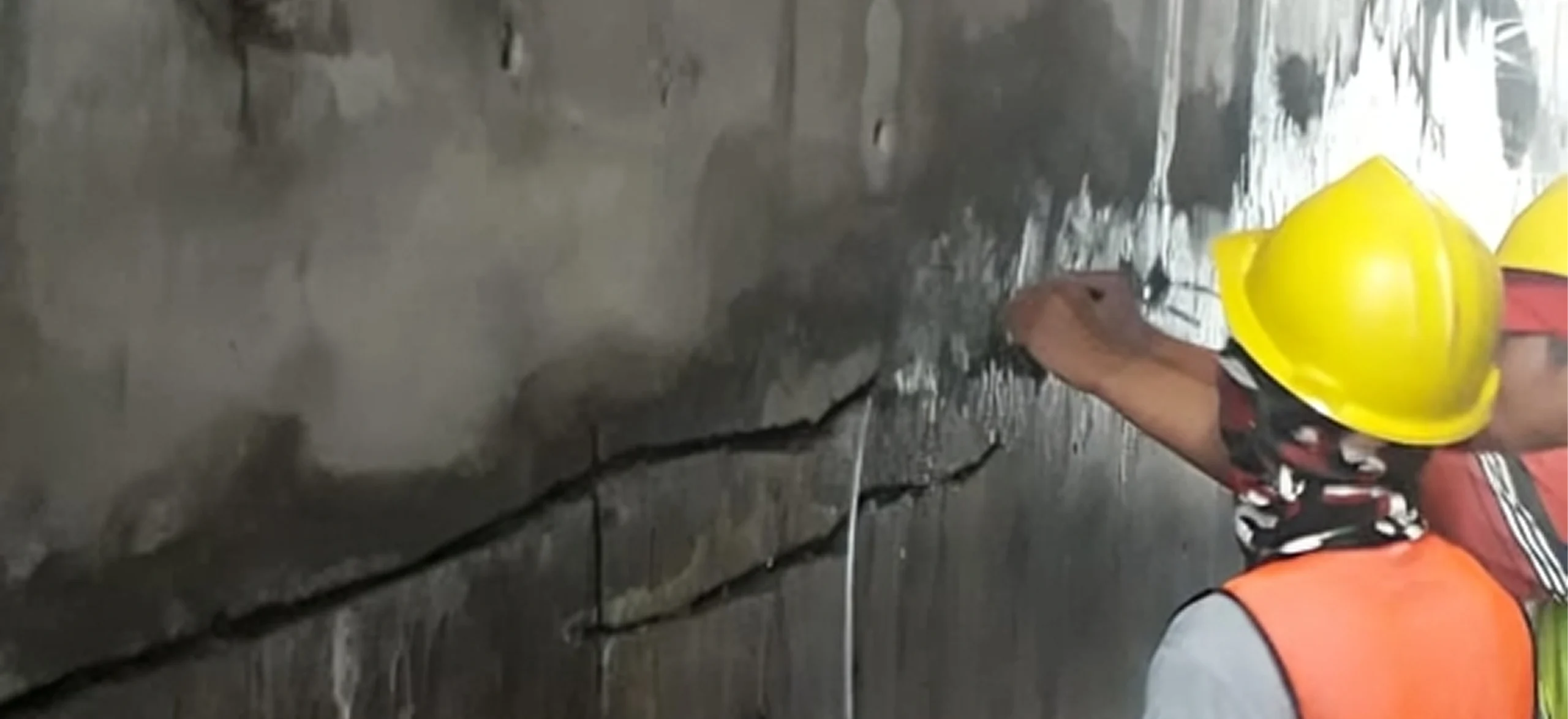 Pekerja Aqushield menangani retakan pada dinding beton